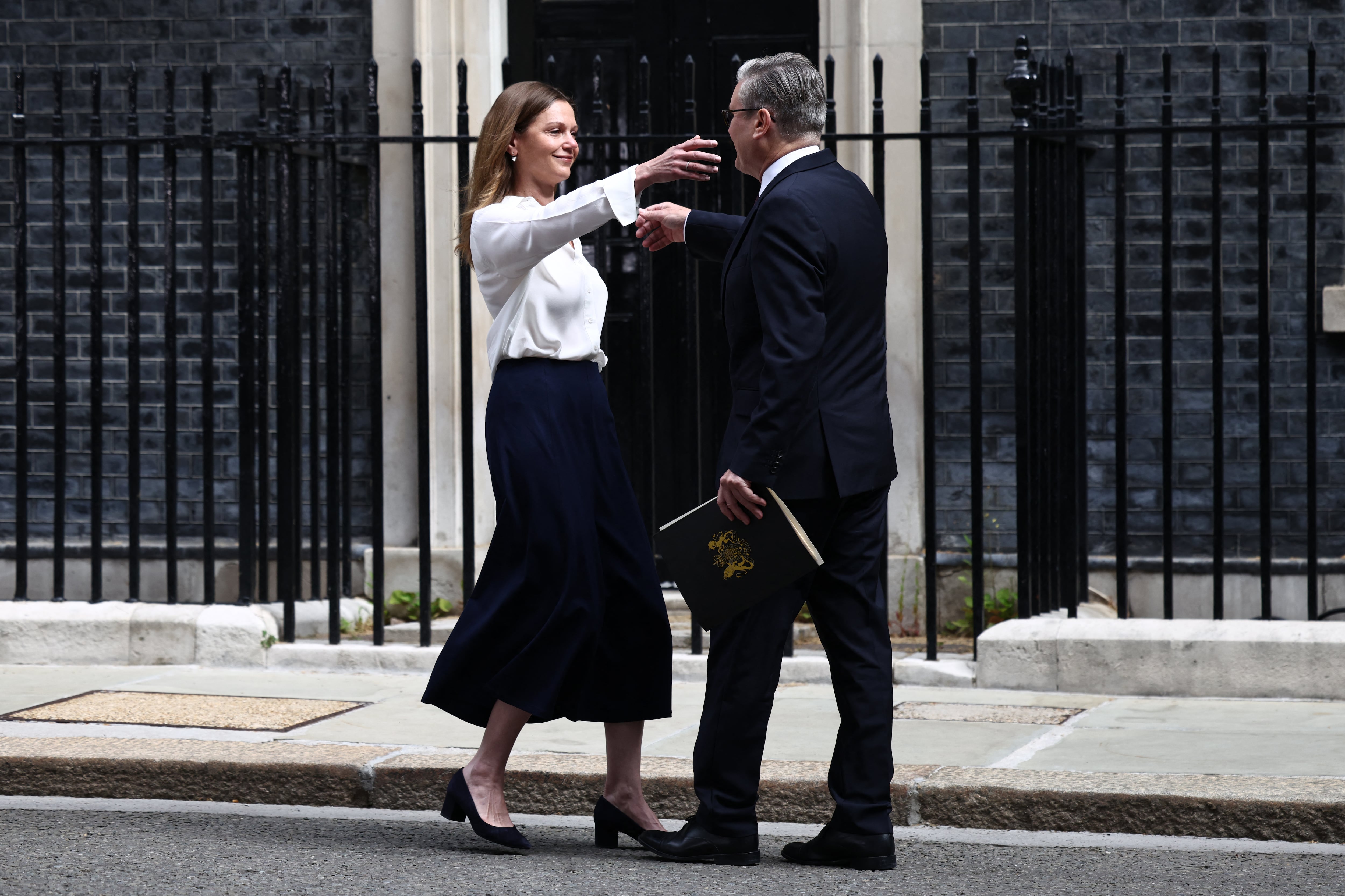 La esposa del primer ministro británico, Victoria Starmer (izquierda), abraza al primer ministro Keir Starmer (derecha) tras una declaración sobre su futuro al frente del número 10 de Downing Street la mañana del 22 de junio de 2026 en Londres. El primer ministro británico, Keir Starmer, anunció su dimisión el lunes tras menos de dos años en el cargo, un mandato marcado por cambios de rumbo en sus políticas y una profunda impopularidad pública. (Foto de Henry Nicholls / AFP)