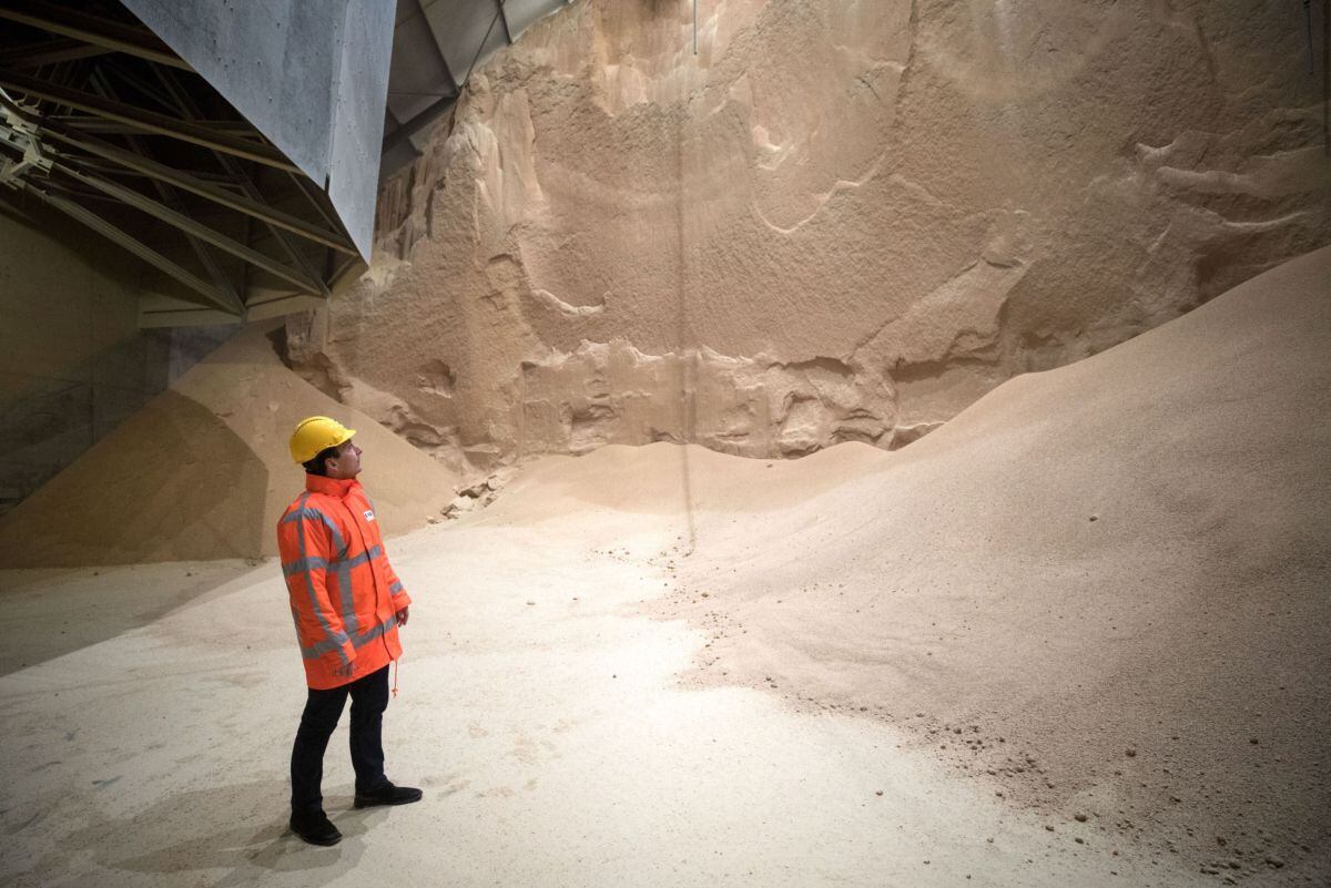 An employee looks at soybean meal produced by Glencore Plc as it is stored before transportation in a grain flat storage at the European Bulk Services (E.B.S.) terminal at the Port of Rotterdam in Rotterdam, Netherlands, on Tuesday, April 25, 2017. Since taking over Glencore Agriculture in 2002, Chris Mahoney has overseen the transformation of the unit into a standalone enterprise that generates more revenue from owning fixed assets in strategic locations than simply trading.