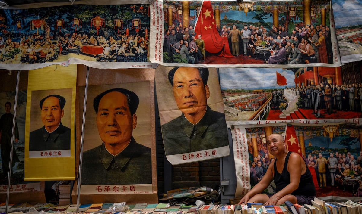 Un vendedor de libros y recuerdos, algunos con la imagen de Mao Zedong, espera clientes en el Mercado de Antigüedades de Panjiayuan, en Beijing. (AFP / NOEL CELIS).