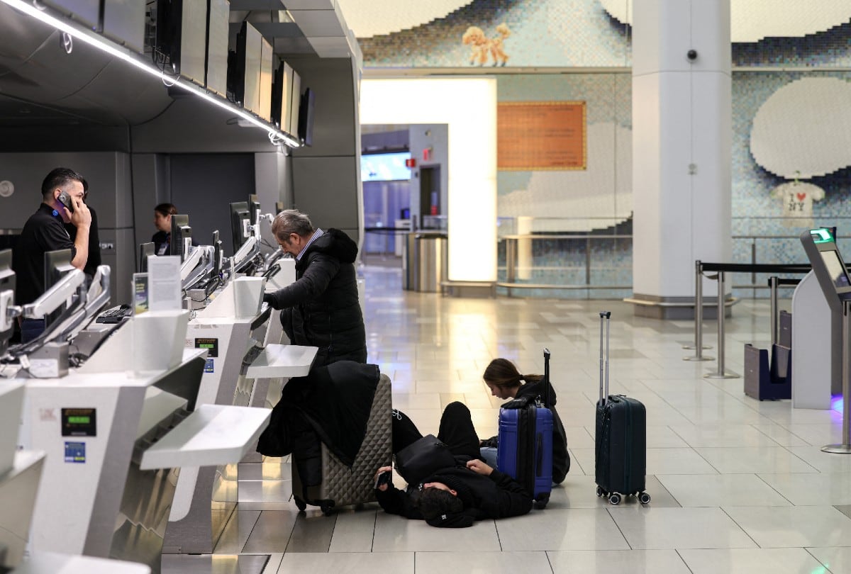 Pasajeros esperan en el suelo del aeropuerto LaGuardia, en Nueva York, el 25 de enero de 2026, tras cancelaciones masivas de vuelos por una tormenta invernal en EE. UU. | Crédito: CHARLY TRIBALLEAU / AFP