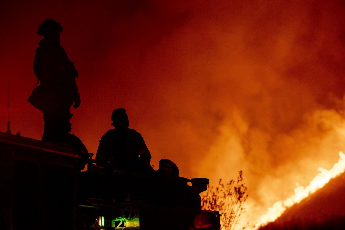 Los bomberos observan desde un camión de bomberos en Charlie Canyon Road durante el incendio Hughes en Castaic, California, el 22 de enero.