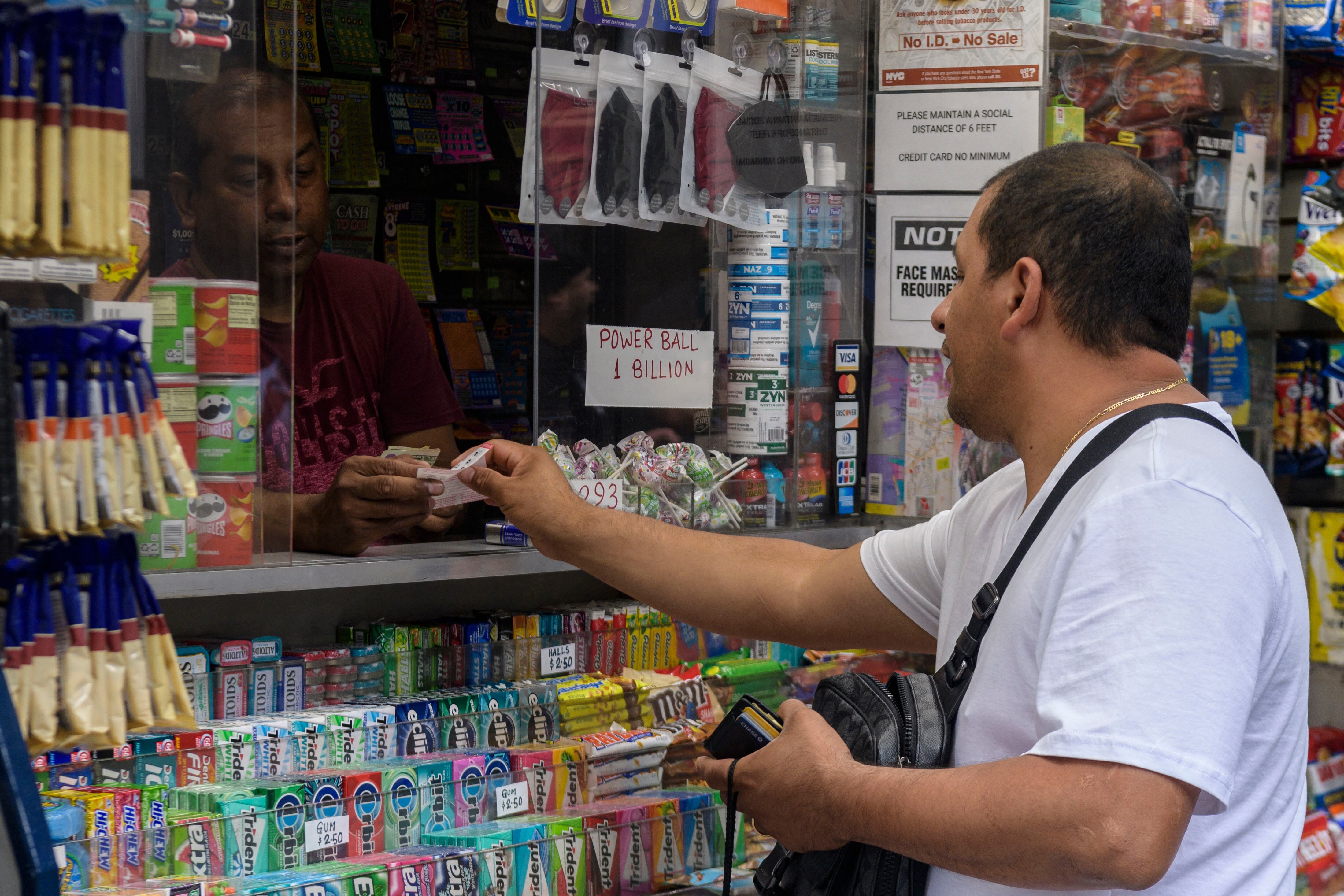 Una persona compra boletos de Powerball en un quiosco de periódicos en la ciudad de Nueva York el 19 de julio de 2023 (Foto: AFP)