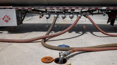 A fuel tanker delivers fuel to a gas station in the US.