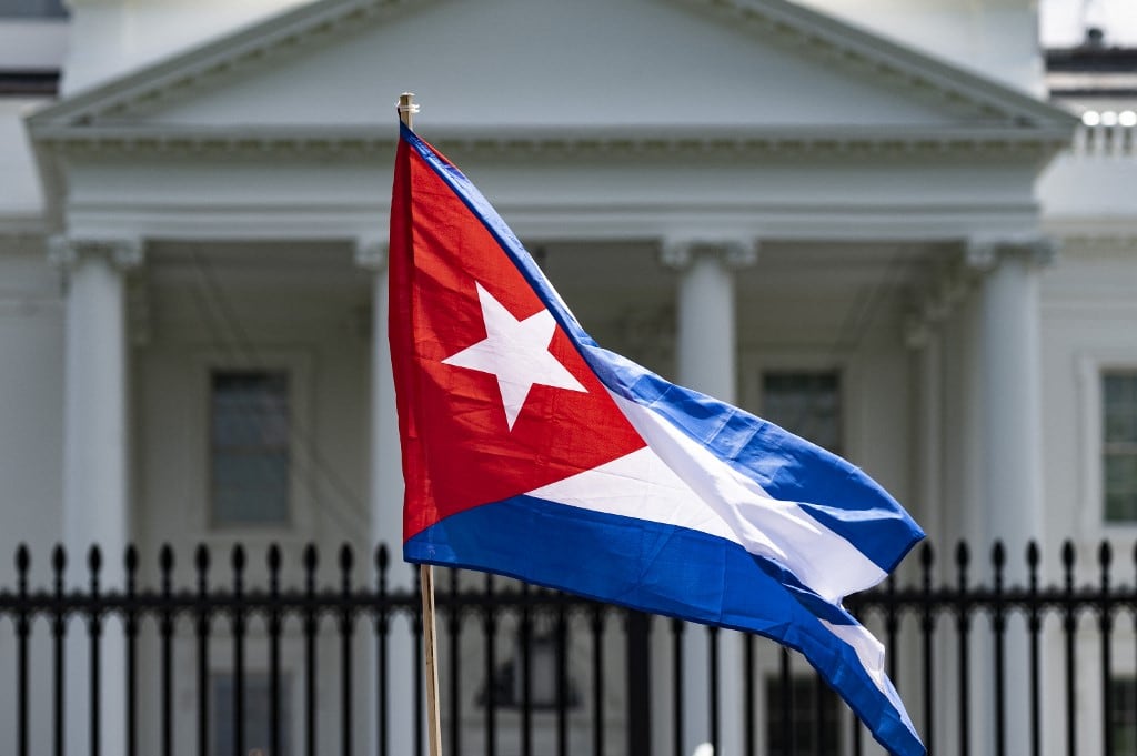 Un manifestante sostiene la bandera cubana mientras en una protesta frente a la Casa Blanca en Washington, DC. (Foto de JIM WATSON / AFP)