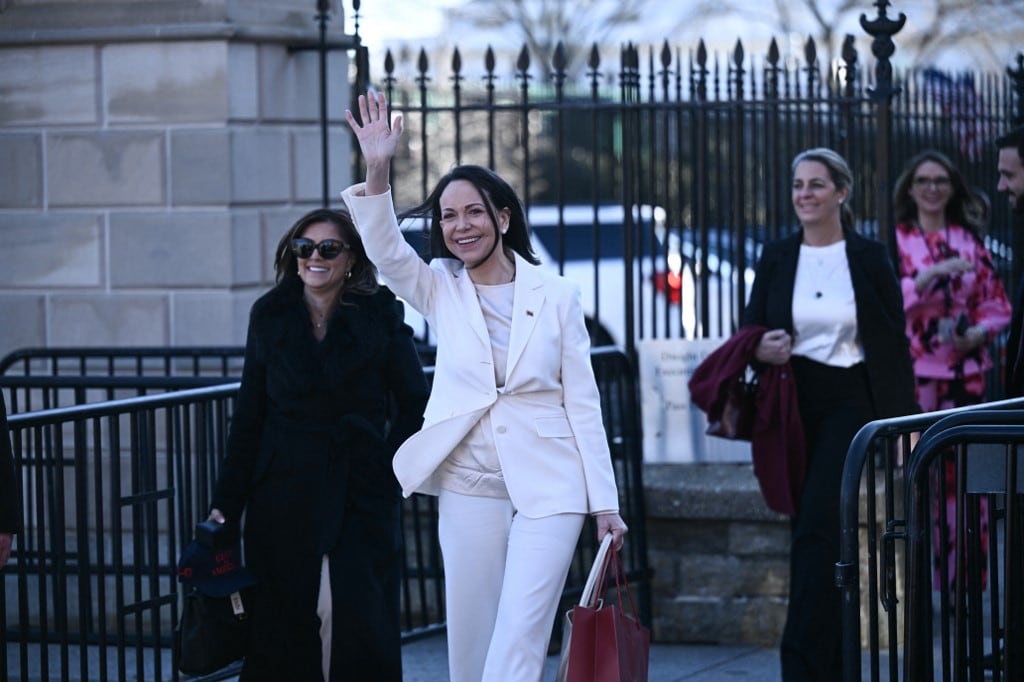 La líder opositora venezolana, María Corina Machado, saluda a sus partidarios al salir de la Casa Blanca tras reunirse con el presidente estadounidense Donald Trump en Washington, D.C., el 15 de enero de 2026. (Foto de Brendan SMIALOWSKI / AFP)
