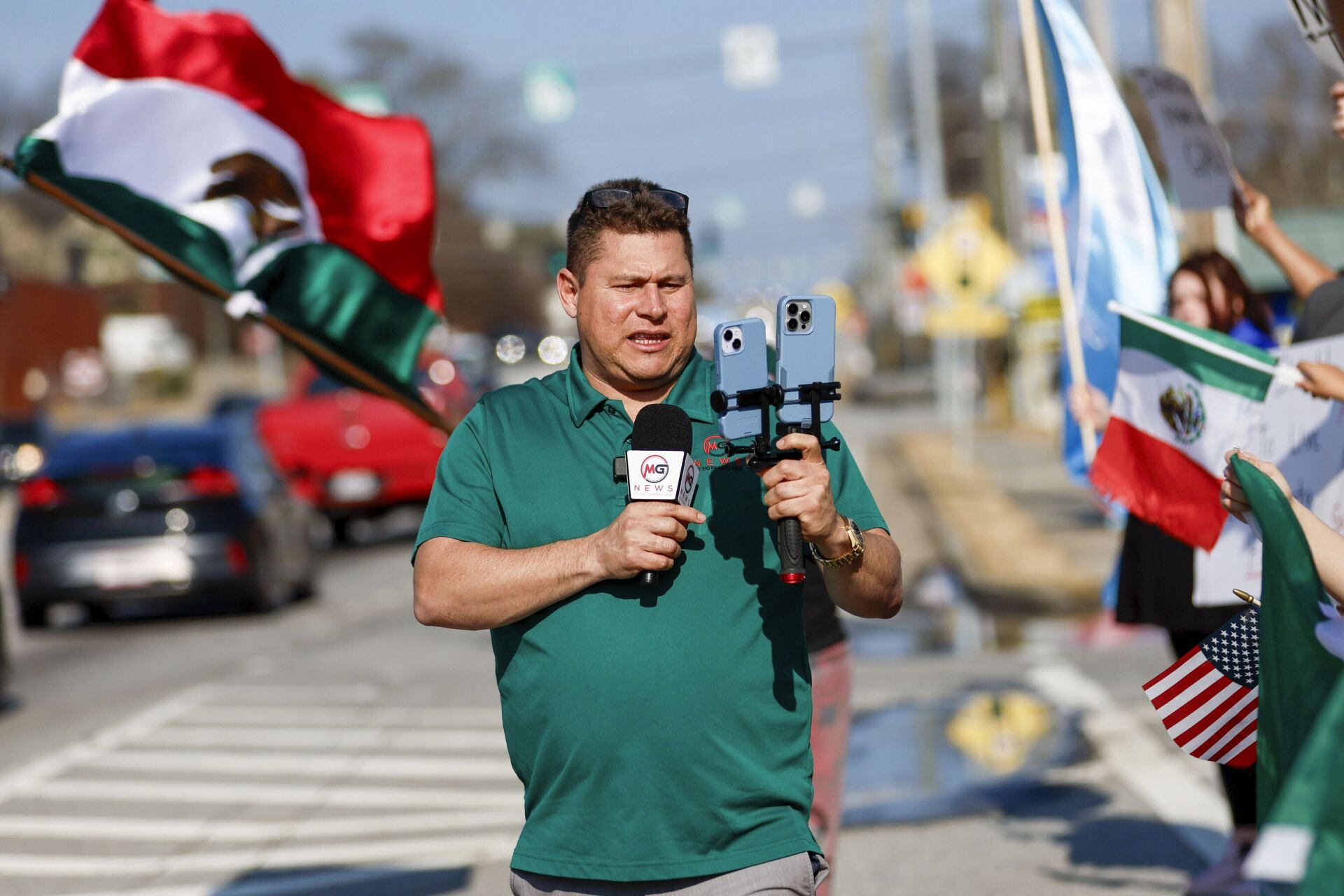 Mario Guevara, reportero de habla hispana del área metropolitana de Atlanta, cubre una protesta contra la aplicación de las leyes de inmigración en la autopista Buford, Georgia, el sábado 1 de febrero de 2025. (Miguel Martinez/Atlanta Journal-Constitution vía AP)