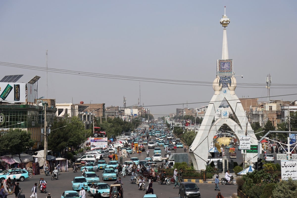 (ARCHIVO) Esta fotografía, tomada el 1 de julio de 2026, muestra a pasajeros viajando en taxis azules en una plaza de Herat. (Foto de Mohsen KARIMI / AFP)