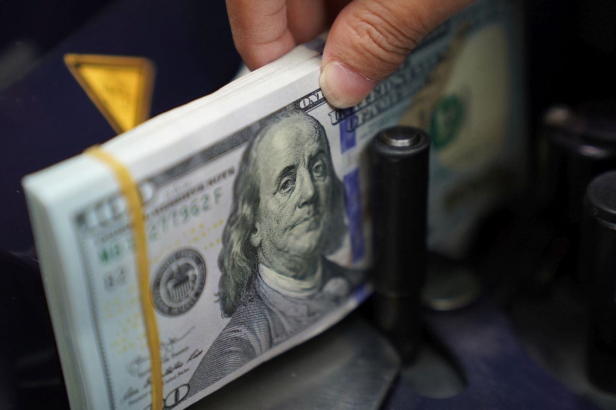A worker counts U.S. dollar banknotes at a currency exchange office in Jakarta, Indonesia. Photographer: Dimas Ardian/Bloomberg