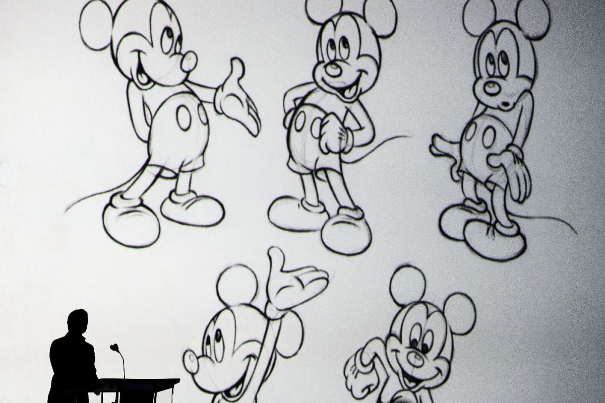 Bob Iger, left, near drawings of Mickey Mouse. Photographer: Patrick T. Fallon/Bloomberg