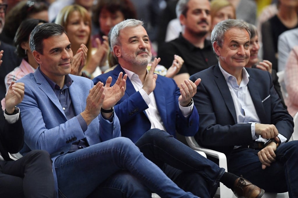 El presidente del Gobierno español, Pedro Sánchez (izq.), aplaude junto al candidato a la alcaldía de Barcelona, Jaume Collboni (centro), y el expresidente del Gobierno, José Luis Rodríguez Zapatero, en el acto de clausura de la campaña electoral del Partido Socialista Obrero Español (PSOE) en Barcelona, el 26 de mayo de 2023, antes de las elecciones autonómicas y municipales del 28 de mayo. (Foto de Pau BARRENA / AFP)
