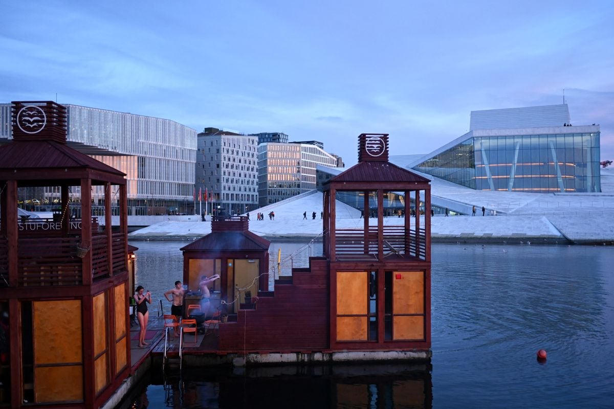 La gente visita la sauna en la bahía de Bjorvika en el centro de Oslo, el 9 de diciembre de 2022. (Foto de Sergei GAPON / AFP)