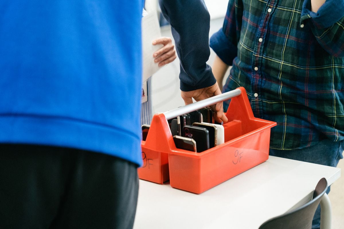 Un alumno de la clase 9F muestra cómo depositan sus teléfonos inteligentes en una caja especial al comienzo de la jornada en la escuela integral de habla sueca Kungsvagens skola, el 21 de agosto de 2025 en Sipoo, Finlandia.