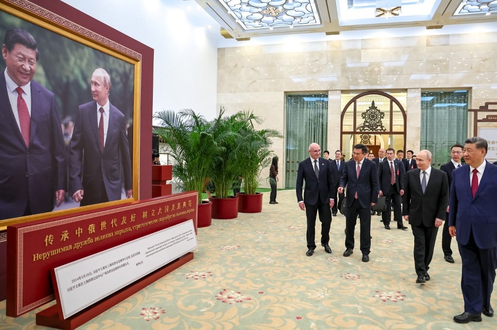 En esta fotografía compartida por la agencia estatal rusa Sputnik, el presidente ruso Vladimir Putin y el presidente chino Xi Jinping visitan una exposición fotográfica sobre las relaciones entre Rusia y China en Pekín el 20 de mayo de 2026. (Foto de Alexander KAZAKOV / POOL / AFP)
