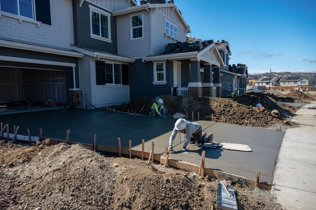 Trabajadores pavimentan la entrada de una nueva vivienda en la urbanización Rosemary Grove, construida por Taylor Morrison en Vacaville, California, EE.UU.