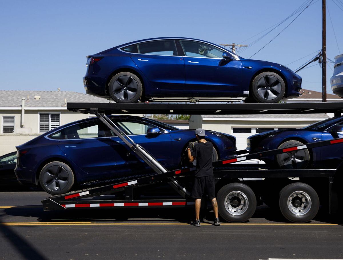 Un trabajador descarga autos Tesla Model 3 en California. Foto: Patrick T. Fallon/Bloomberg
