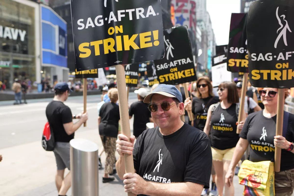 ARCHIVO - El actor Jason Kravits con un cartel en un mitin frente a Paramount en Times Square en Nueva York (Foto Charles Sykes/Invision/AP)