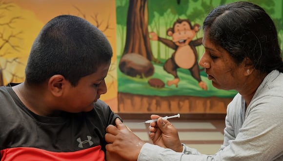 Un trabajador de la salud inocula a un estudiante de escuela con una dosis de la vacuna 'Corbevax' durante una campaña de vacunación para niños en el grupo de edad de 12 a 14 años, en Bangalore el 9 de mayo de 2022. (Foto de Manjunath Kiran / AFP)