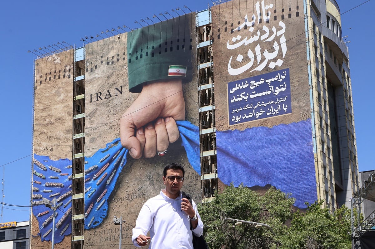Una valla publicitaria en la fachada de un edificio que representa el estrecho de Ormuz con una leyenda en persa que dice "Siempre en manos de Irán", en la plaza Vanak de Teherán, el 25 de mayo de 2026. (ATTA KENARE / AFP) /