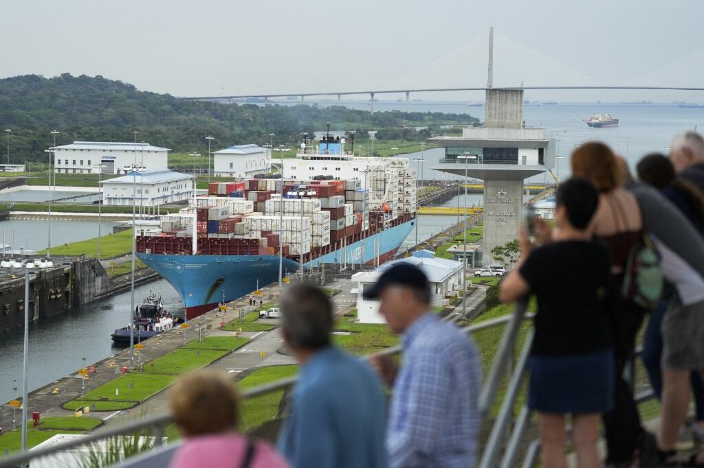 Turistas observan el carguero danés Lars Maersk navegando por las esclusas de Agua Clara del Canal de Panamá en la ciudad de Colón, Panamá, el 28 de diciembre de 2024. (Foto: ARNULFO FRANCO / AFP)