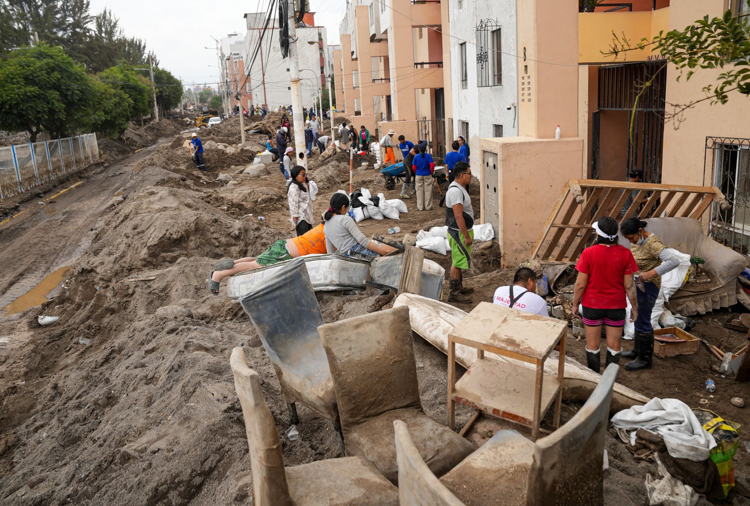Habitantes de la zona limpian los escombros causados por las fuertes lluvias en Arequipa, el 25 de febrero de 2026 (Foto: Diego Ramos / AFP)