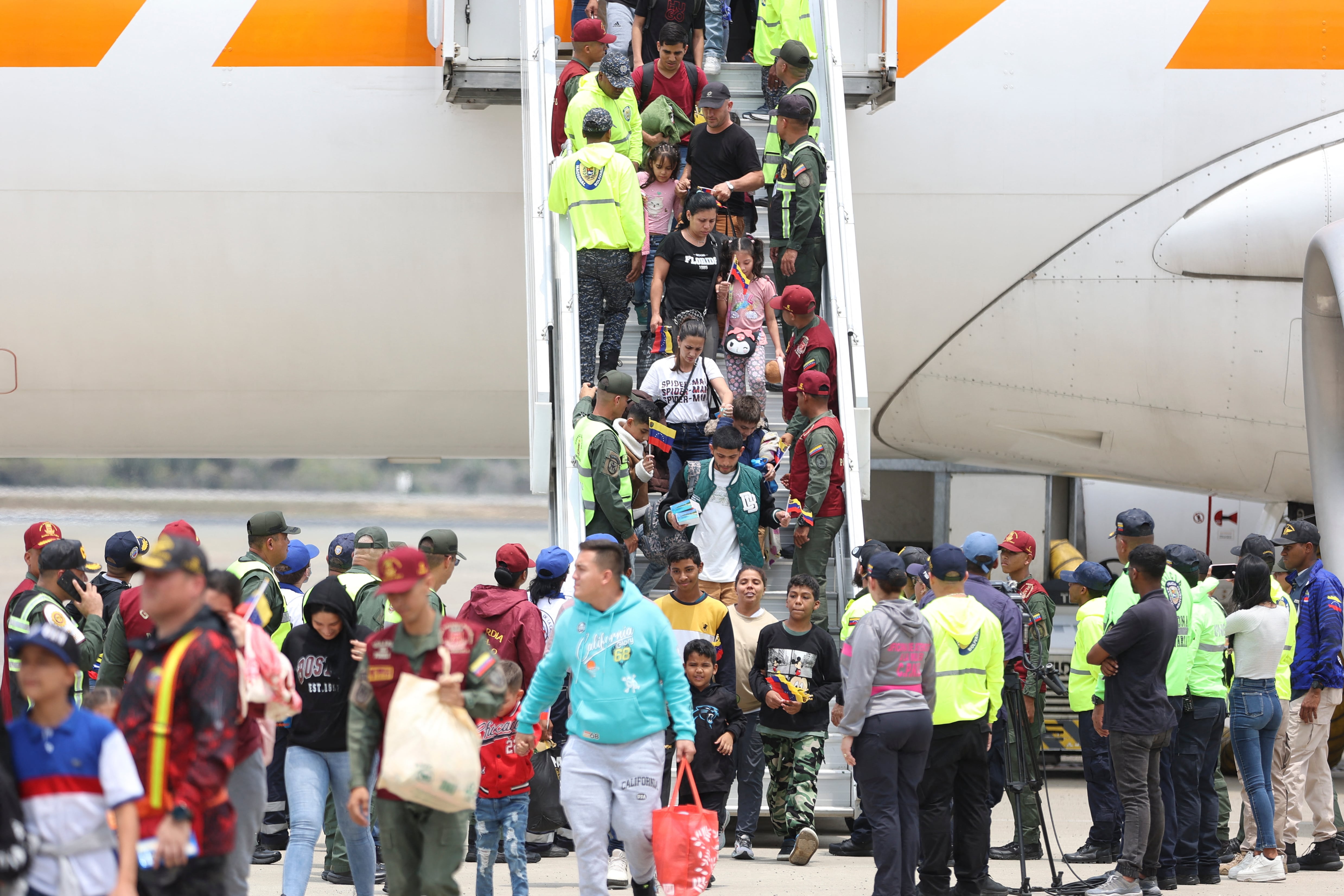 Migrantes venezolanos descienden de un avión a su llegada al Aeropuerto Internacional Simón Bolívar en Maiquetía, Venezuela, el 20 de marzo de 2025. (Foto de Pedro MATTEY / AFP )