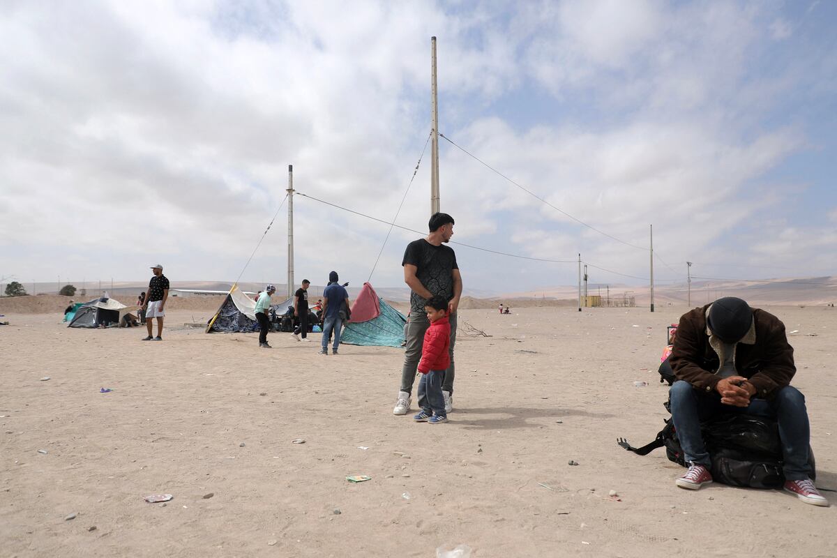 Migrantes venezolanos esperan información para ingresar a Perú, en Arica, en la frontera entre Chile y Perú, el 4 de mayo de 2023. (Foto de AGUSTÍN MERCADO / AFP)