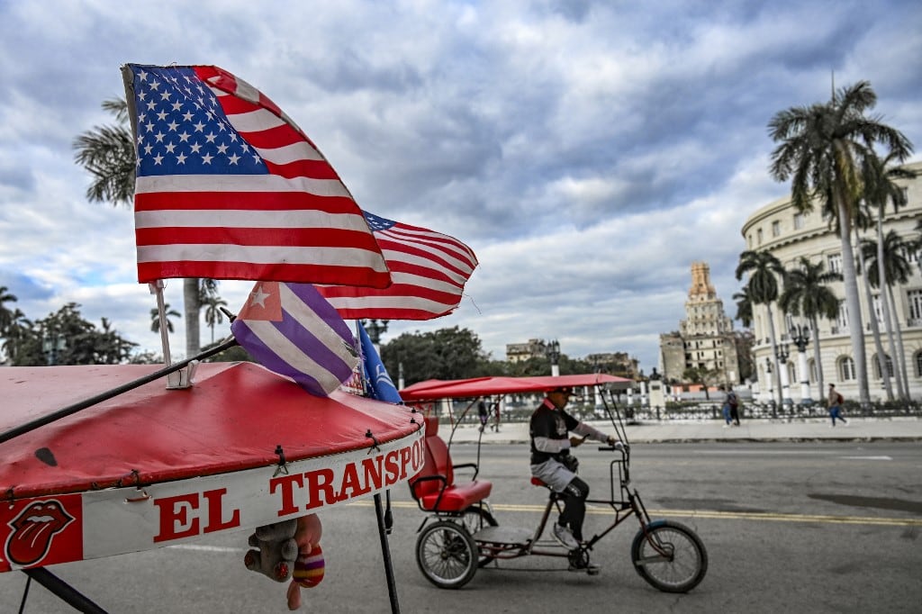 Dos banderas estadounidenses y una cubana ondean en el techo de un triciclo frente al Capitolio de La Habana el 3 de febrero de 2026. El gobierno cubano declaró a la AFP el 2 de febrero que estaba en comunicación con la administración del presidente estadounidense Donald Trump, pero que aún no había iniciado conversaciones formales para alcanzar un acuerdo que pusiera fin a la campaña de presión de Washington sobre la isla. (Foto de YAMIL LAGE / AFP)