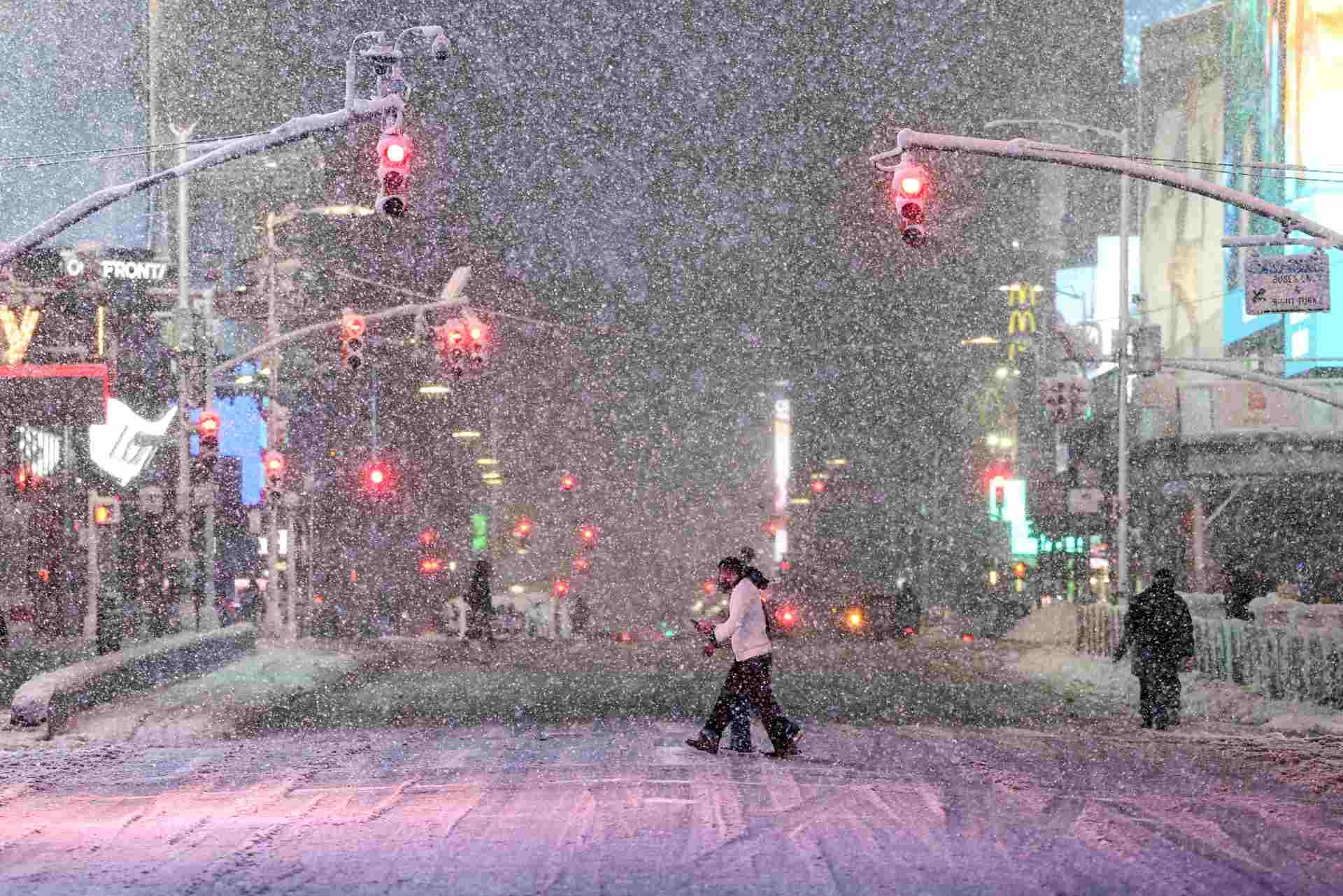 Personas caminan por Times Square, Manhattan, durante una nevada en la ciudad de Nueva York, el 22 de febrero de 2026. (Foto de CHARLY TRIBALLEAU / AFP)