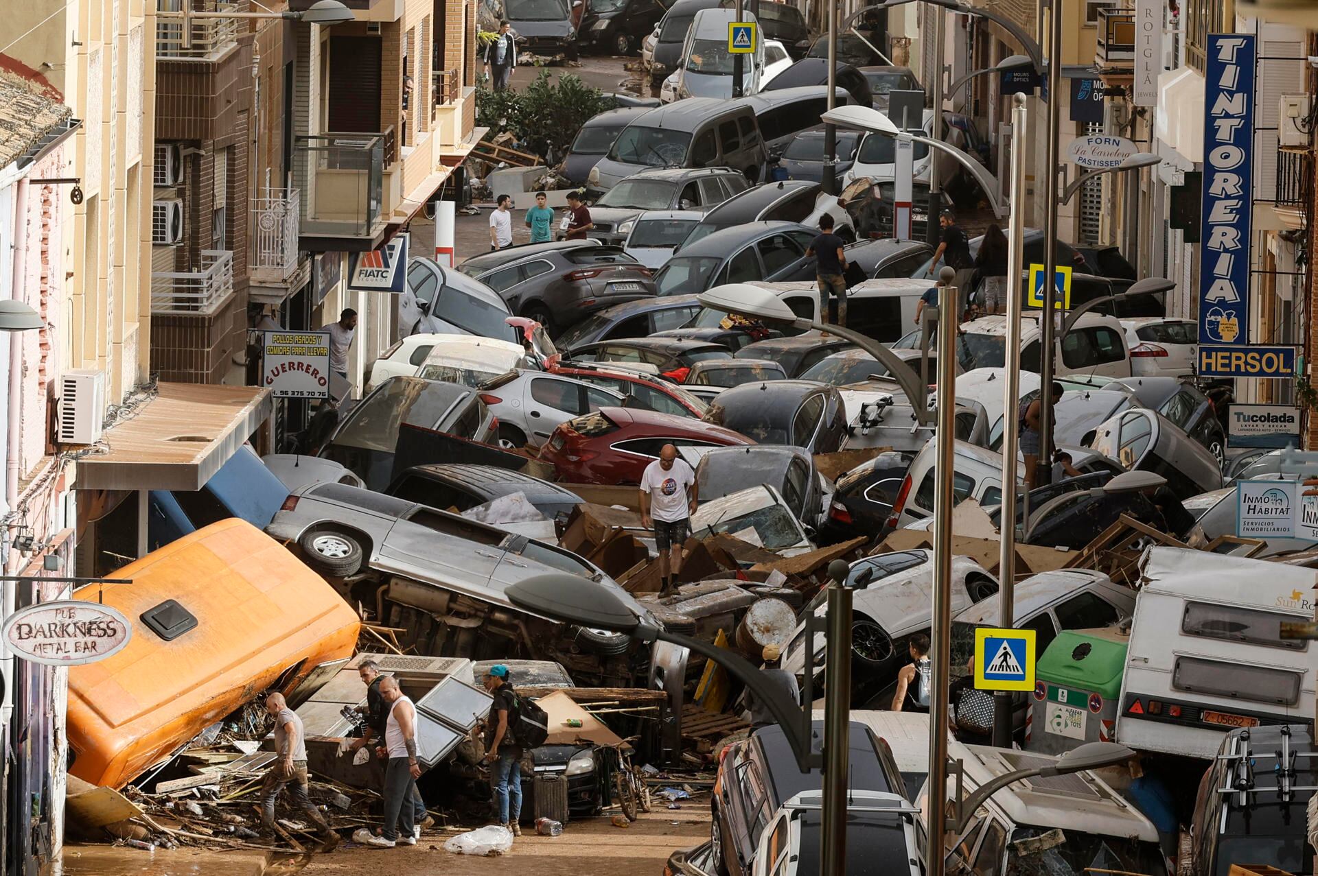 Vehículos amontonados en una calle tras las intensas lluvias de la fuerte dana que afecta Valencia, en España. (EFE/Biel Aliño).