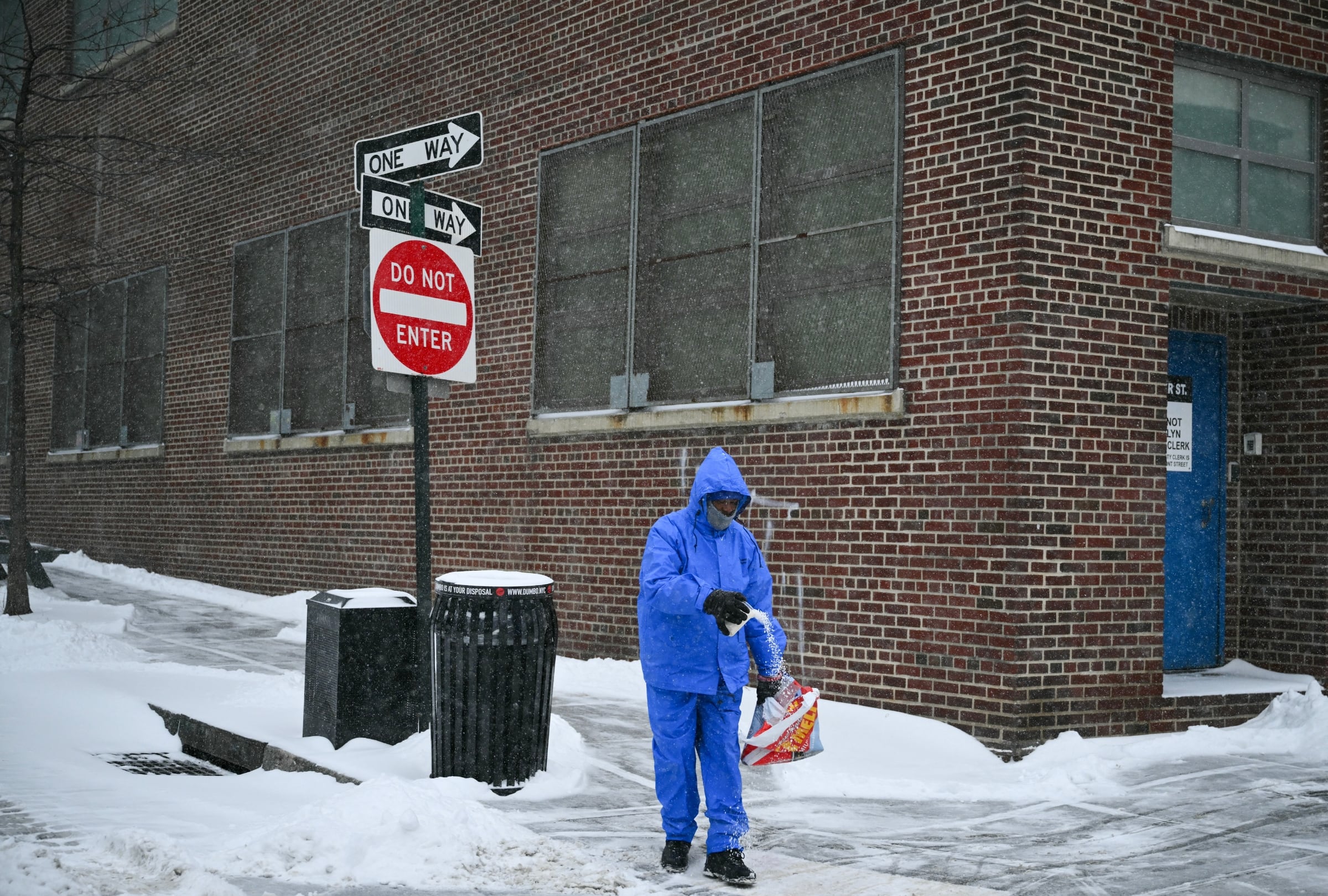 Un hombre echa sal en una acera mientras nieva en el barrio de Brooklyn, en la ciudad de Nueva York, el 25 de enero del 2026 (Foto: Angela Weiss / AFP)