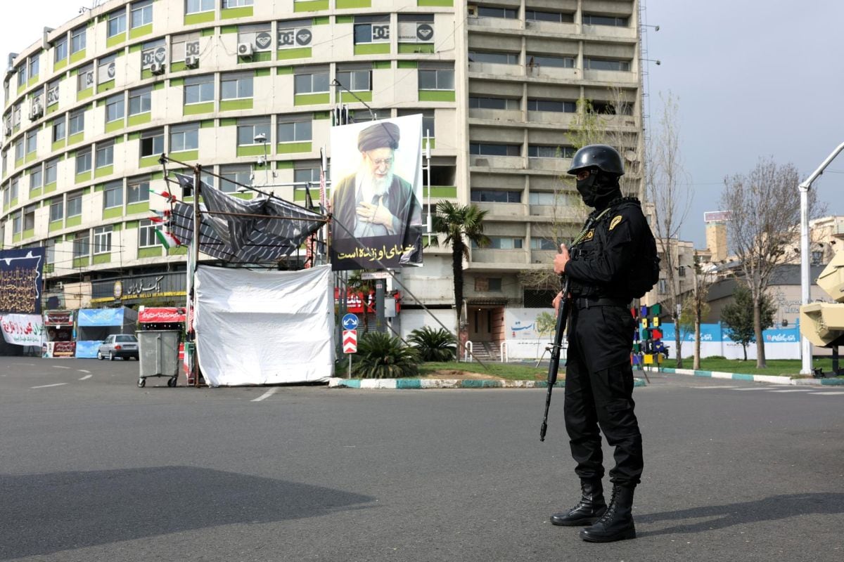 Un miembro de las fuerzas de seguridad iraníes monta guardia junto a una pancarta con la imagen del fallecido líder supremo iraní, el ayatolá Ali Khamenei, en Teherán, Irán, el 31 de marzo de 2026. Foto: EFE/EPA/ABEDIN TAHERKENAREH