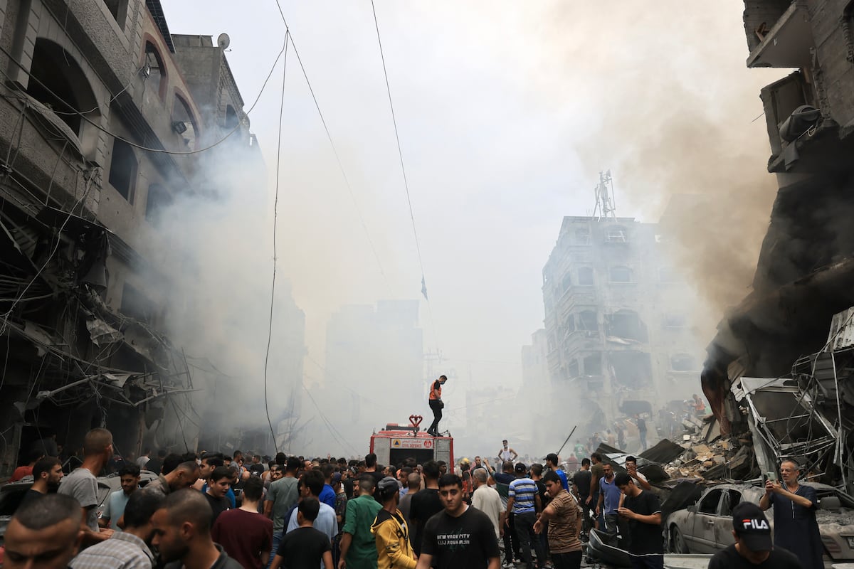 Palestinos buscan supervivientes después de un ataque aéreo israelí contra edificios en el campo de refugiados de Jabalia, en la Franja de Gaza, el 9 de octubre de 2023. (Foto de Mahmud HAMS / AFP).