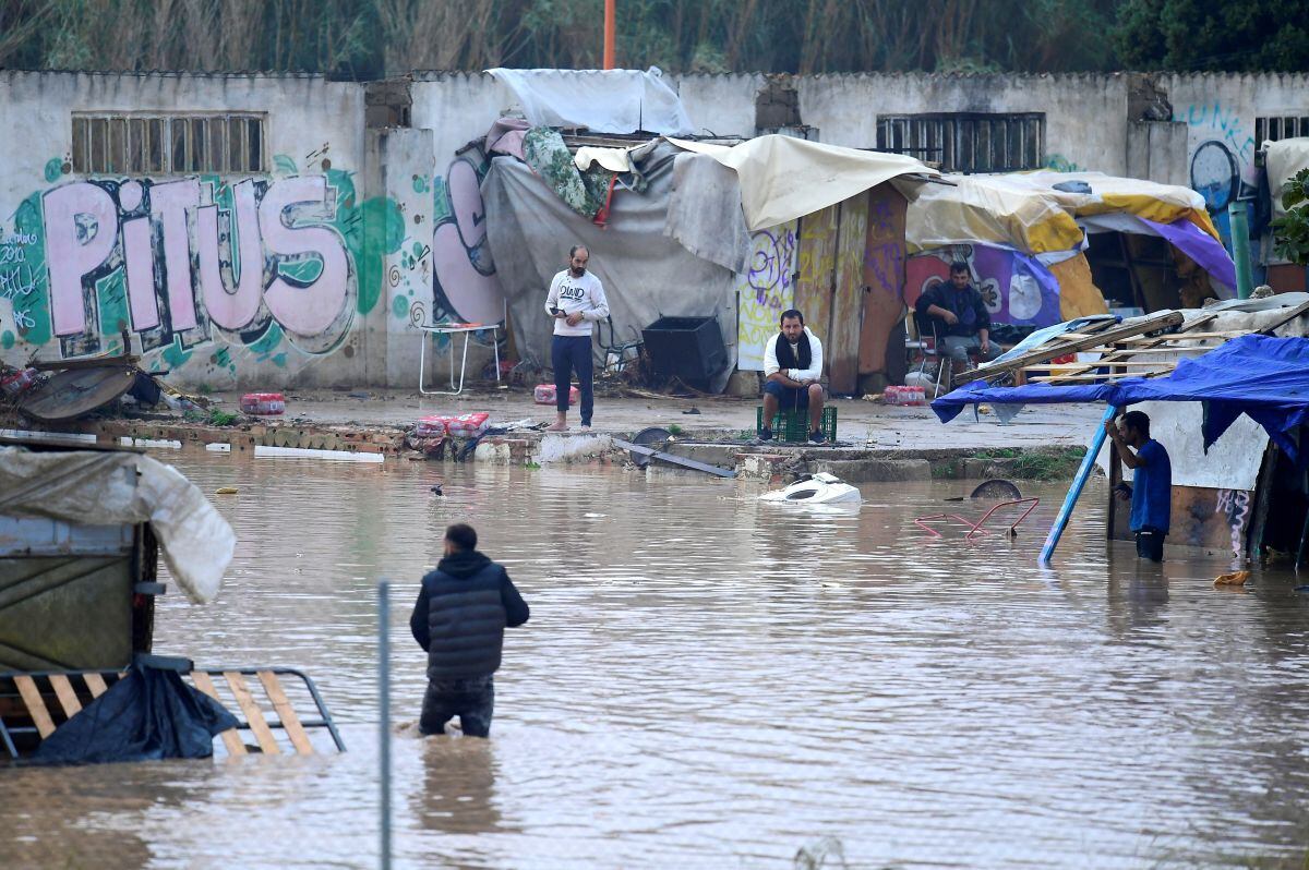 Los hombres se encuentran en una zona de tugurios inundada en Picanya, cerca de Valencia, este de España, el 30 de octubre de 2024 (Foto: José Jordán /AFP)