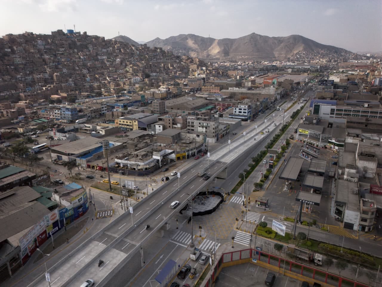 Panorámica desde el aire que expone la extensión total del viaducto elevado cruzando una zona comercial e industrial densamente poblada, rodeada por cerros característicos de este sector de la capital. Foto: Antonio Melgarejo / @photo.gec