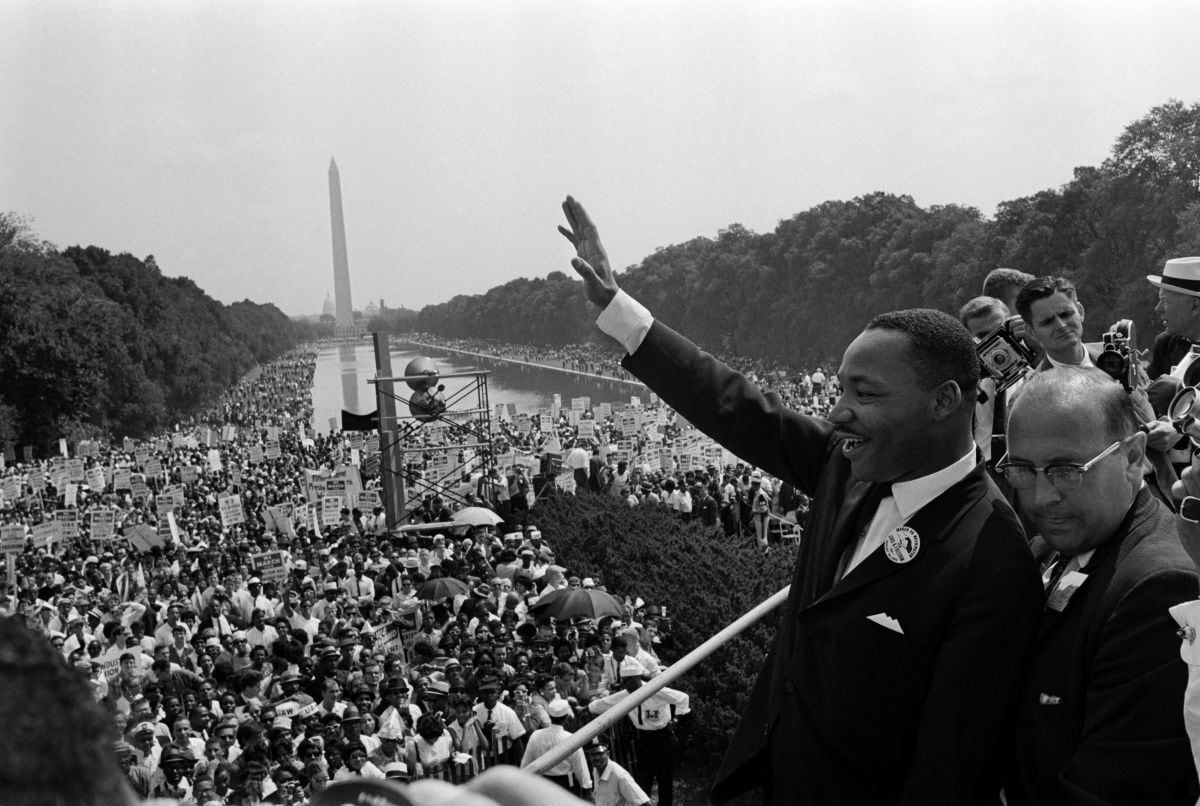 Martin Luther King saluda a sus simpatizantes el 28 de agosto de 1963 en el Mall de Washington D. C. durante la "Marcha sobre Washington", donde pronunció su famoso discurso "Tengo un sueño". | Crédito: AFP