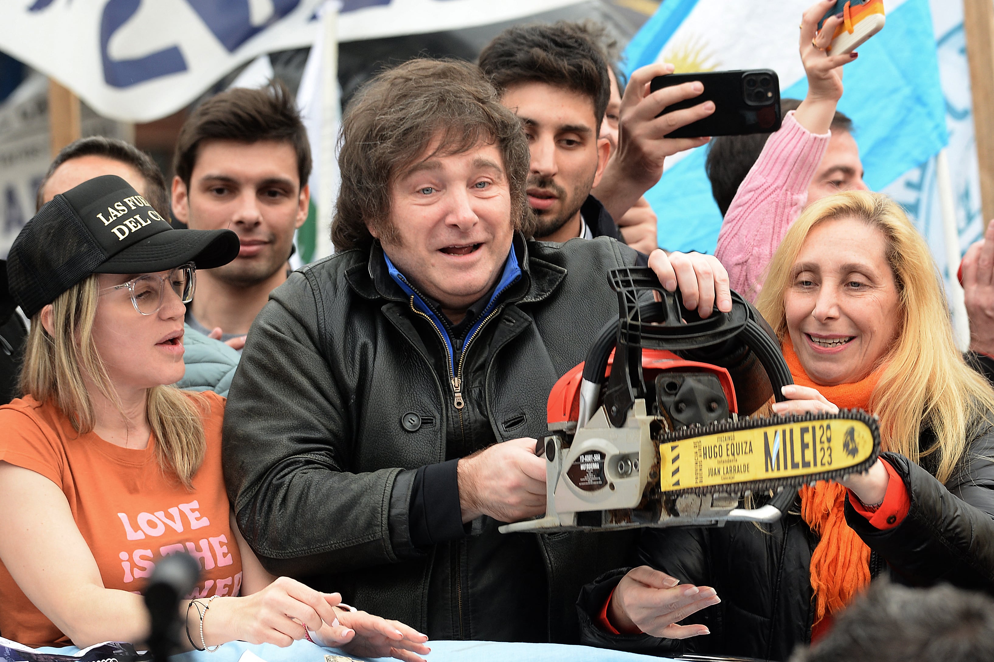 Javier Milei agita una motosierra entre su hermana Karina Milei y la candidata a gobernadora de la provincia de Buenos Aires, Carolina Píparo, durante un mitin político en La Plata, el 12 de septiembre de 2023. (AFP).
