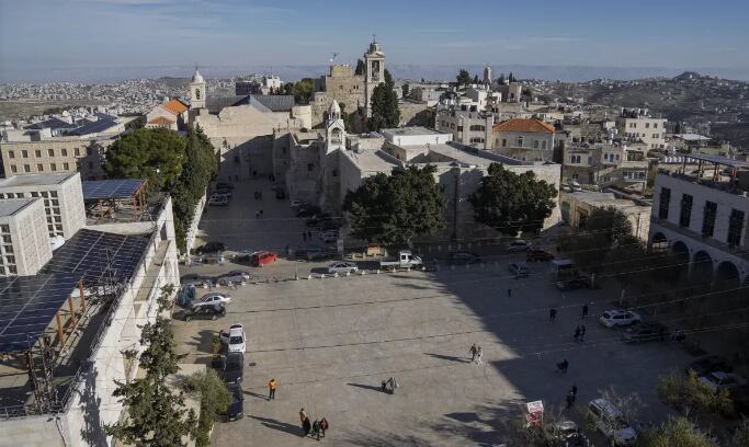 Varias personas caminan en la plaza de Manger, junto a la Basílica de la Natividad, que se cree es el lugar de nacimiento de Jesucristo, en la ciudad de Belén, en Cisjordania. (Foto: AP Foto/Mahmoud Illean)