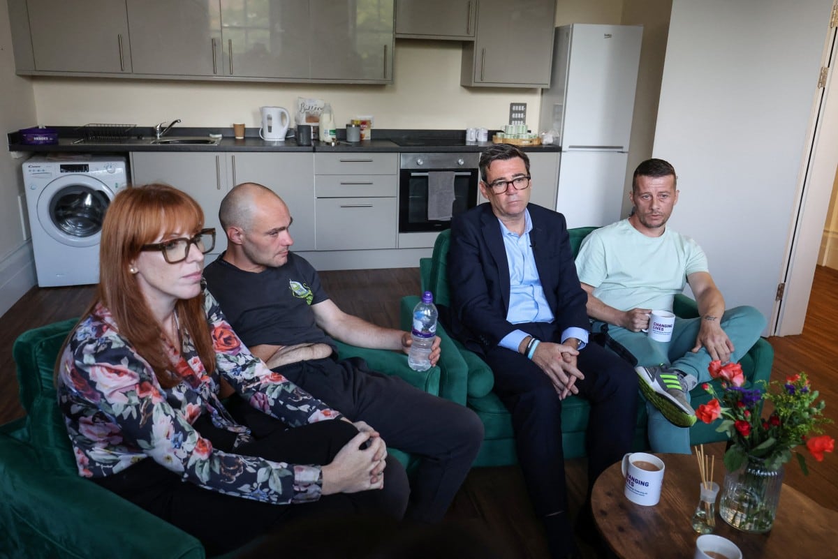 El primer ministro británico, Andy Burnham (segundo por la derecha), y la secretaria de Vivienda británica, Angela Rayner (izquierda), conversan con usuarios y miembros del personal durante una visita a la organización benéfica para personas sin hogar Changing Lives en Newcastle, al noreste de Inglaterra, el 19 de agosto de 2026. (Foto de SCOTT HEPPELL / POOL / AFP)