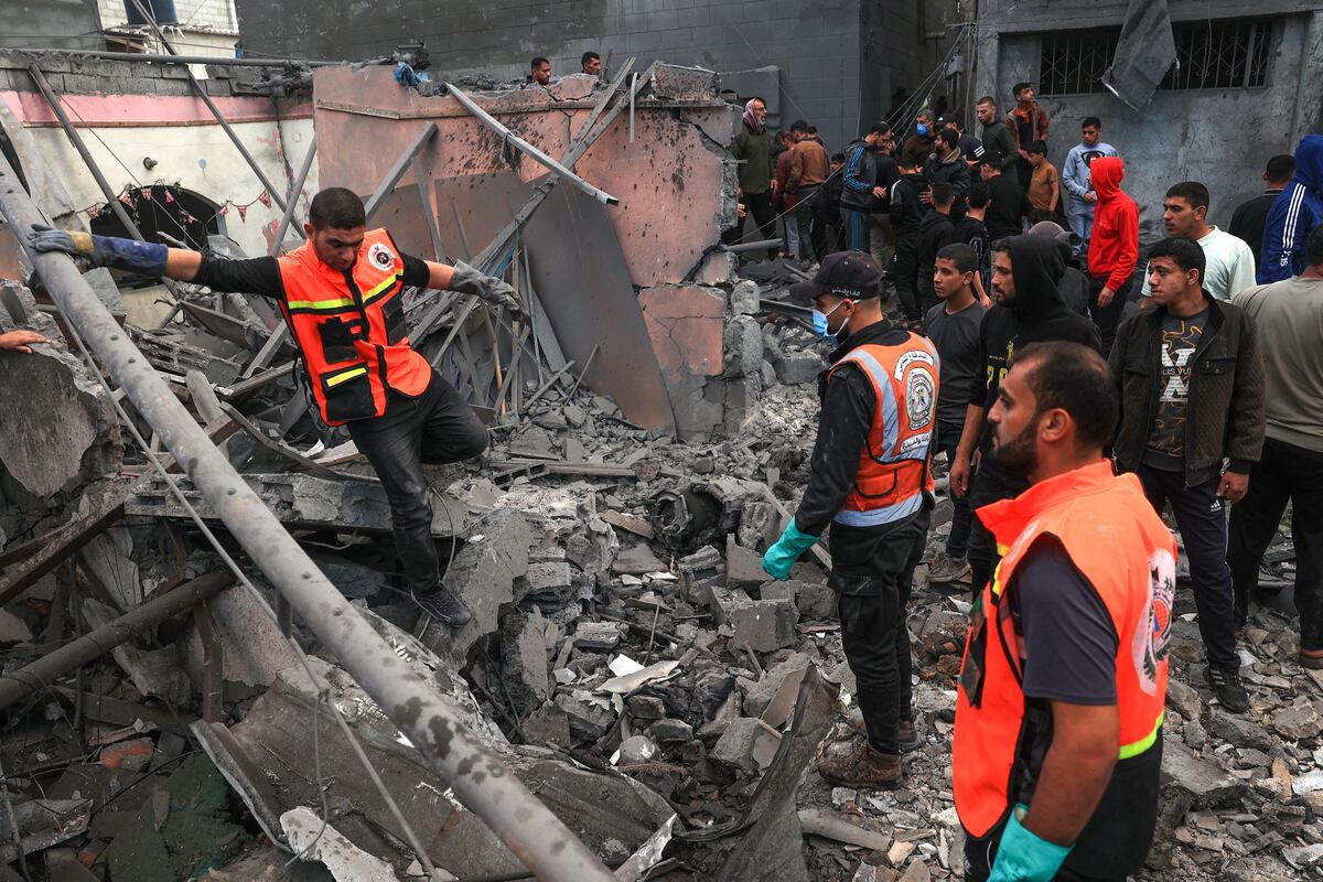 Los médicos palestinos buscan supervivientes entre los escombros de un edificio tras el bombardeo israelí en Rafah, en el sur de la Franja de Gaza, el 1 de diciembre de 2023, cuando los combates se reanudaron poco después de la expiración de una tregua de siete días entre Israel y militantes de Hamás. (Foto de SAID KHATIB / AFP)