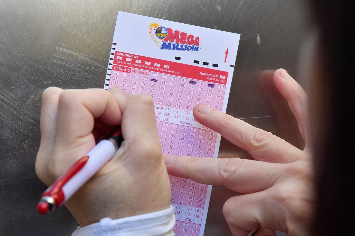 Una mujer llena un billete de lotería Mega Millions el 19 de octubre de 2018 en la ciudad de Nueva York, con la esperanza de convertirse en millonaria (Foto: Angela Weiss / AFP)
