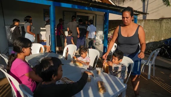 Natalia Contreras, una migrante venezolana, atiende a sus hijos mientras se preparan para desayunar en Rio Branco, Brasil. (Foto: AP)
