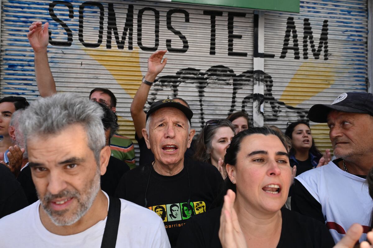 Periodistas y personas se manifiestan frente a la sede de la agencia estatal de noticias Telam durante una protesta mientras miembros de la Policía Federal Argentina vigilan la entrada en Buenos Aires el 4 de marzo de 2024. (Foto de Luis ROBAYO/AFP)