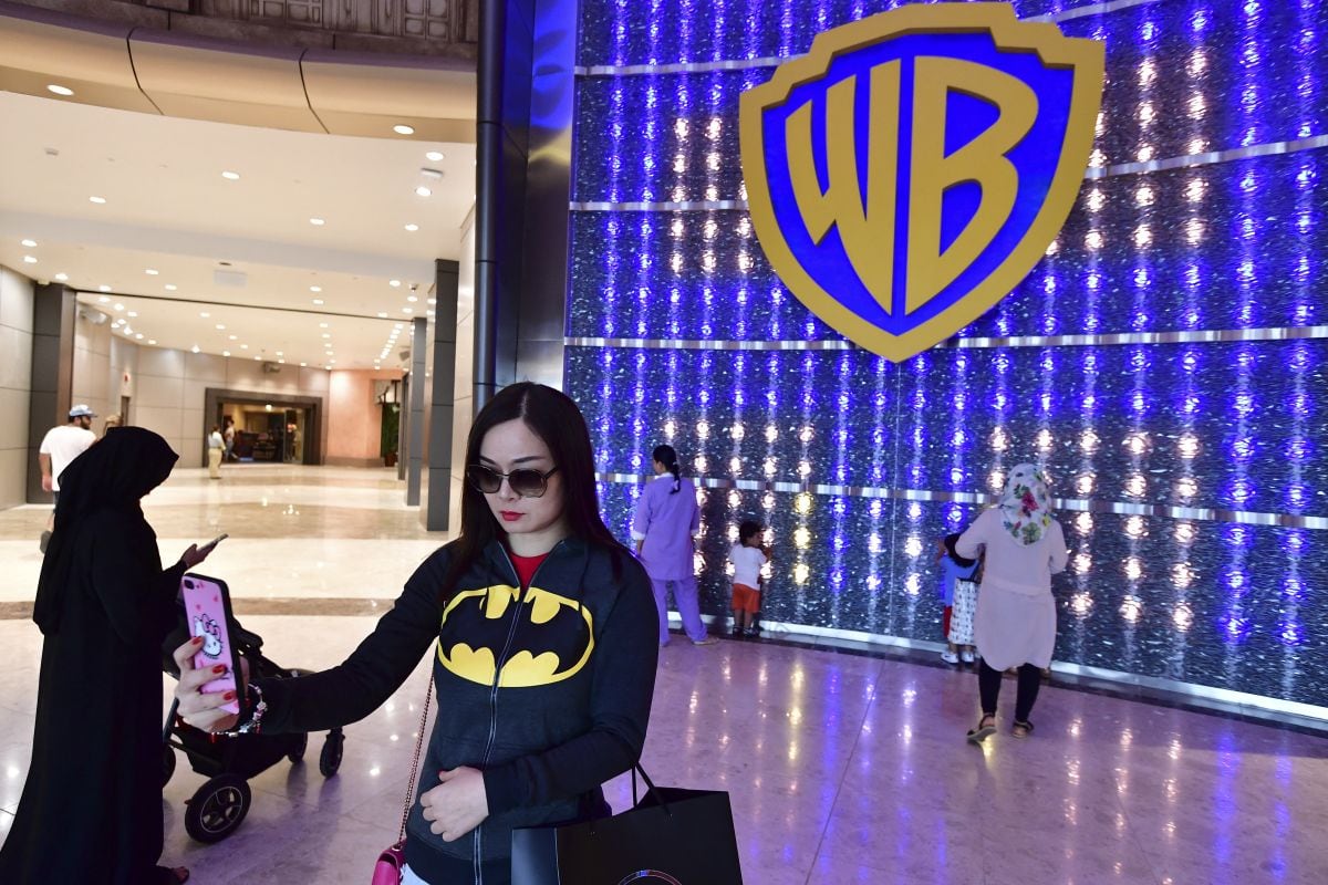 Una mujer se toma una selfi con el logo en Warner Bros. World, el primer parque temático cubierto de la marca Warner, en Abu Dabi, la capital de los Emiratos Árabes Unidos, el 27 de julio de 2018 (Foto: Giuseppe Cacace / AFP)