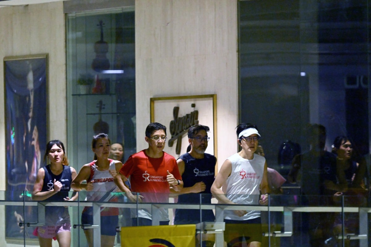 El golpeteo de las zapatillas de correr resuena en un centro comercial de Singapur, donde personas deseosas de hacer ejercicio buscan refugio frente a una bruma asfixiante. (Foto de Roslan RAHMAN / AFP)