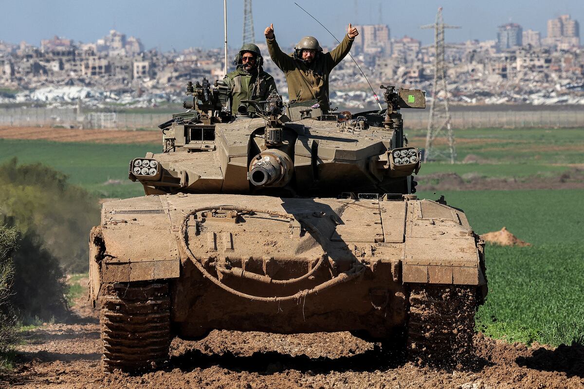 Un soldado del ejército israelí hace gestos mientras está sentado en la torre de un tanque de batalla que se mueve en una posición a lo largo de la frontera entre el sur de Israel y la Franja de Gaza el 31 de enero de 2024 en medio del conflicto en curso entre Israel y el grupo militante palestino Hamás. (Foto de JACK GUEZ / AFP)