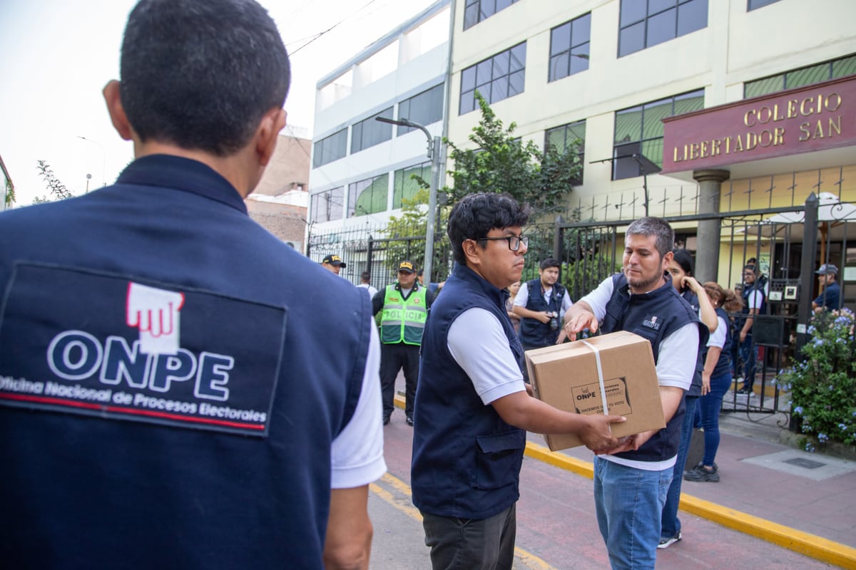 Integrantes de la Oficina Nacional de Procesos Electorales (ONPE) ingresan material electoral, en el colegio Libertador San Martín en Lima, el 12 de abril de 2026. (Renato Pajuelo / EFE)