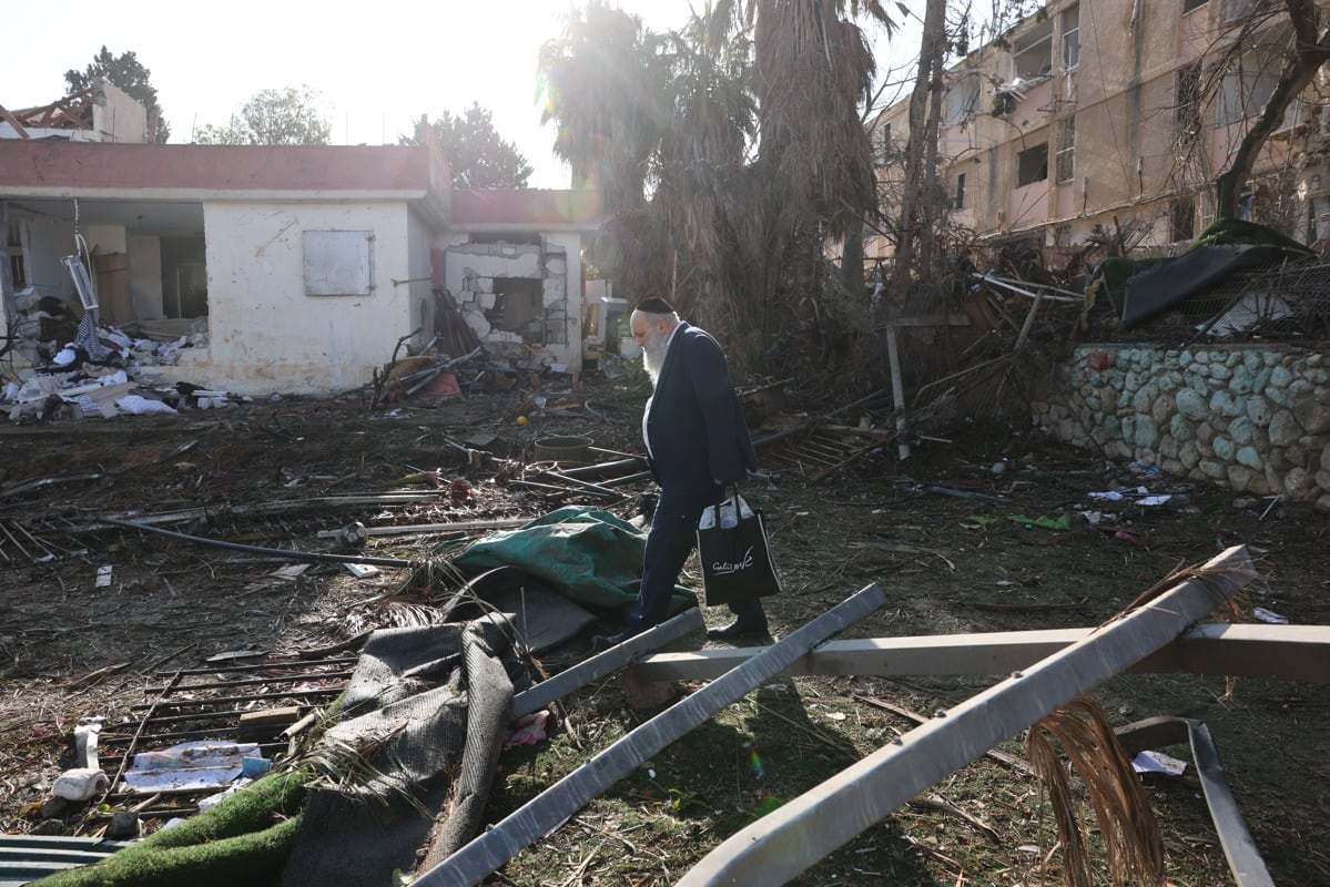 Varias personas observan la escena donde un misil iraní impactó directamente en un barrio residencial de Dimona, Israel, el 22 de marzo de 2026. (EFE/EPA/ABIR SULTAN)