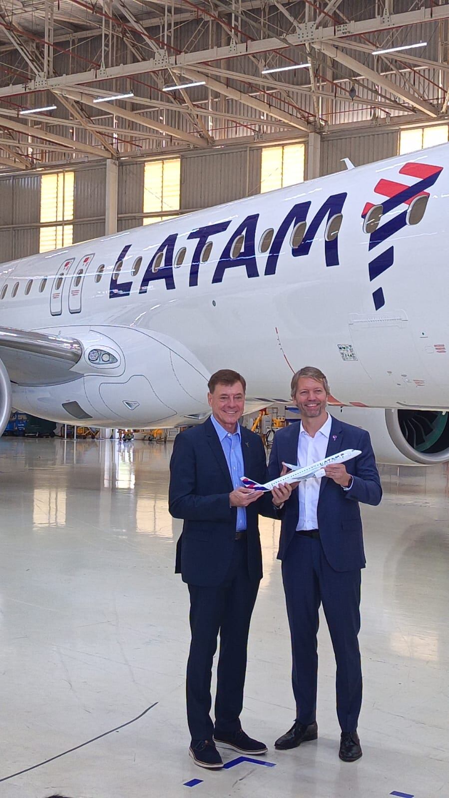 Francisco Gomes Neto, presidente y CEO de Embraer y Jerome Cadier, CEO de LATAM Airlines Brasil, sostienen un modelo a escala menor del primer E195-E2 que adquiere la aerolínea. Foto: F. Cuadros / Gestión