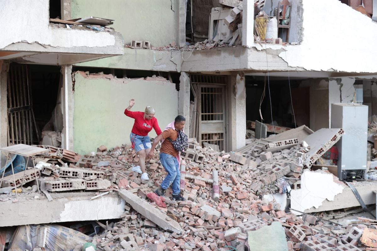 Residentes caminan entre los escombros de una de las viviendas dañadas por los terremotos, en la localidad de Catia La Mar, en el estado costero de La Guaira (Venezuela) este jueves. EFE/ Ronald Pena R.