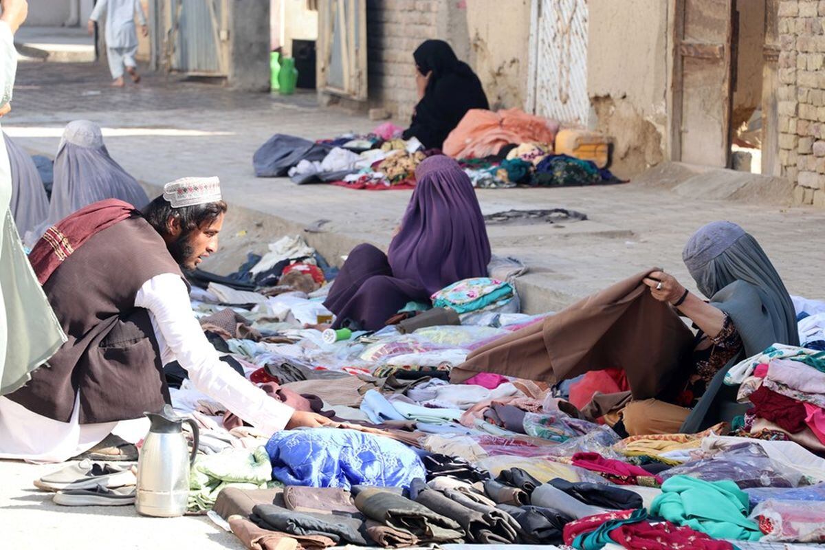Mujeres afganas venden ropa usada al costado de la carretera, en una fotografía de archivo. EFE/EPA/STRINGER